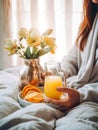 Beautiful woman having breakfast in bed, home bedroom interior with bright morning light, healthy food on cozy decorated