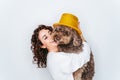 A beautiful woman having fun with her Spanish water dog in a party at home. She is putting a golden top hat on the dog`s head. Ne Royalty Free Stock Photo