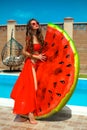 Beautiful woman having fun with watermelon float mattress by swimming pool on villa resort. Sexy girl enjoy summer vacation. Royalty Free Stock Photo