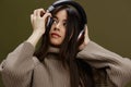 beautiful woman in headphones listening to music emotions Green background