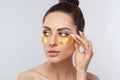 Beautiful woman with healthy perfect skin holds patchs. Beauty face with gold cosmetics collagen hydrogel patch. Royalty Free Stock Photo