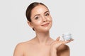 Beautiful Woman with healthy smooth facial clean skin holding bottle cosmetic cream. Model with Beauty face. Royalty Free Stock Photo