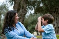 Beautiful woman and her cute little son looking at each other, son making the mimic of taking picture of the mother