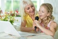 Beautiful woman with her daughter at home singing karaoke Royalty Free Stock Photo