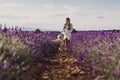 Beautiful woman with her golden retriever dog in lavender fields at sunset. Pets outdoors and lifestyle Royalty Free Stock Photo