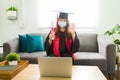 Happy young woman graduating in a virtual graduation at home Royalty Free Stock Photo