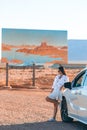 Beautiful woman on her trip by the car on the background of Welcome to Utah state border sign right in the Monument Royalty Free Stock Photo