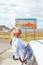 Beautiful woman on her trip by the car. Welcome to Utah road sign. Large welcome sign greets travels in Monument Valley Royalty Free Stock Photo