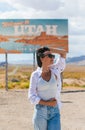 Beautiful woman on her trip by the car. Welcome to Utah road sign. Large welcome sign greets travels in Monument Valley Royalty Free Stock Photo