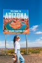 Beautiful woman on her trip to the USA on the background of Welcome to Arizona State border sign right in the Paje Royalty Free Stock Photo