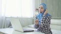 Beautiful woman in hijab at the computer with headset, distant work, call center Royalty Free Stock Photo