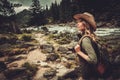 Beautiful woman hiker enjoying amazing landscapes near wild mountain river