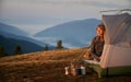 Beautiful woman hiker resting in camp tent in mountains. Royalty Free Stock Photo