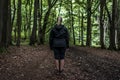 Beautiful woman hiker standing on forest trail looking away. Female on hike in nature spooky mystical forests Royalty Free Stock Photo