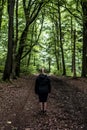 Beautiful woman hiker standing on forest trail looking away. Female on hike in nature spooky mystical forests Royalty Free Stock Photo