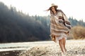 beautiful woman hipster walking on river beach in mountains, having fun and enjoying, boho travel concept, space for text Royalty Free Stock Photo