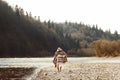 Beautiful woman hipster walking on river beach in mountains, wear