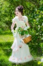 Beautiful woman in an historical bride dress with a wicker basket in her hands Royalty Free Stock Photo