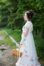 Beautiful woman in an historical bride dress with a wicker basket in her hands Royalty Free Stock Photo