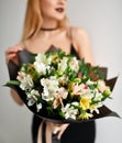 Beautiful woman hold bouquet of chrysanthemum and roses flowers white and purple happy smiling on grey Royalty Free Stock Photo