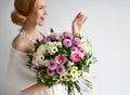 Beautiful woman hold bouquet of chrysanthemum and roses flowers white and purple happy smiling on grey Royalty Free Stock Photo