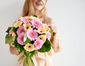 Beautiful woman hold bouquet of gerbera flowers pink and yellow happy smiling on grey Royalty Free Stock Photo