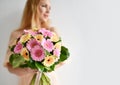 Beautiful woman hold bouquet of gerbera flowers pink and yellow happy smiling on grey Royalty Free Stock Photo