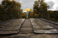 Beautiful woman hold yellow umbrella and walking on a old bridge in the countryside under rain Royalty Free Stock Photo