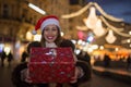 Beautiful woman holding christmas present at night Royalty Free Stock Photo