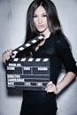 Beautiful woman holding clapperboard