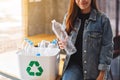 A beautiful woman holding and collecting recyclable garbage plastic bottles into a trash bin at home Royalty Free Stock Photo