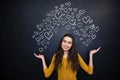 Beautiful woman holding drawing hearts on palms over blackboard