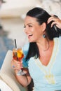 Beautiful woman holding a glass of cocktail near the yacht marine