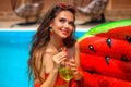 Beautiful woman Holding Glass coctail by watermelon float mattress swimming pool on villa resort. Sexy girl enjoy summer vacation