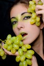 Beautiful woman holding green grapes closeup