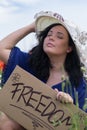 Beautiful woman holding her hat and a paper banner with text