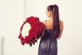 Beautiful woman holding luxury bouquet of 101 roses. Happy Valentine`s day. Luxury fashion girl in evening dress, back view. Royalty Free Stock Photo