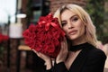 Beautiful woman holding luxury red roses looking at camera Royalty Free Stock Photo