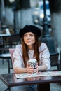 Beautiful woman holding paper coffee cup in the city Young stylish woman drinking coffee to go in a city street Royalty Free Stock Photo