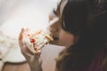 A beautiful woman is holding a piece of pizza and eating it. Pretty asian girl feels happy and enjoy eating the pizza. It looks so Royalty Free Stock Photo