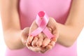 Beautiful woman holding pink ribbon on light background, closeup. Breast cancer concept Royalty Free Stock Photo