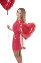Beautiful woman holding red heart balloon over white background.