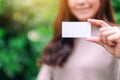 A beautiful woman holding and showing a blank empty business card Royalty Free Stock Photo