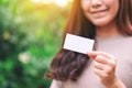 A woman holding and showing a blank empty business card in the outdoors Royalty Free Stock Photo