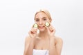 Beautiful woman holding slices of cucumber in front of her eyes Royalty Free Stock Photo