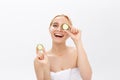 Beautiful woman holding slices of cucumber in front of her eyes Royalty Free Stock Photo