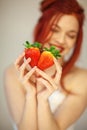 Beautiful woman holding some strawberries in her hands