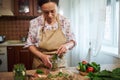 Beautiful woman, housewife pickling cucumbers in home kitchen. Autumn canning of seasonal vegetables for the winter Royalty Free Stock Photo