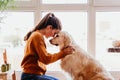 beautiful woman hugging her adorable golden retriever dog at home. love for animals concept. lifestyle indoors