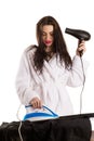 Beautiful woman irons shirt and dries hair